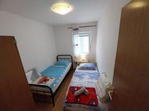 木洛希尼Apartmani Jadran的小房间设有两张床和窗户
