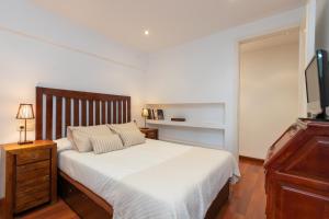 普拉加德阿罗Maria Beach的卧室配有白色的床和电视。