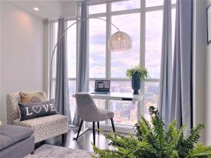 多伦多TVHR - 市中心豪华公寓 的客厅设有一张位于大窗户前的桌子