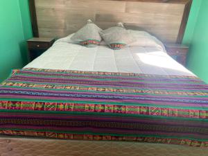 圣佩德罗·德·阿塔卡马Casas Particulares, Tipo Cabañas.的床上有色彩缤纷的毯子和枕头