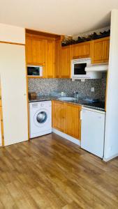 丰罗默奥代洛维亚Font-Romeu : T2 avec grande terrasse et garage的厨房配有白色家电和木制橱柜