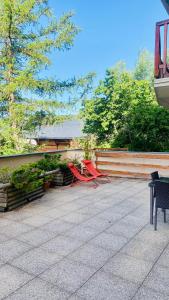 丰罗默奥代洛维亚Font-Romeu : T2 avec grande terrasse et garage的两把红色椅子坐在围栏旁的庭院