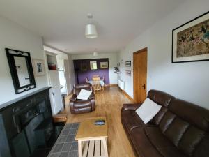 KilfenoraRoadside Cottage The Burren的客厅配有沙发和桌子