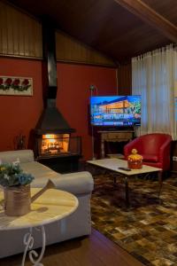坎波斯杜若尔当杜孔迪旅馆的客厅设有壁炉和电视。