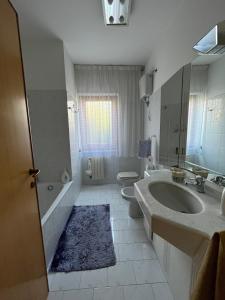 兰恰诺Casa del Verde - spazioso appartamento con terrazzo e giardino的白色的浴室设有水槽和卫生间。