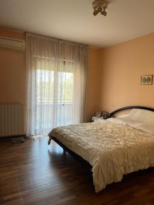 兰恰诺Casa del Verde - spazioso appartamento con terrazzo e giardino的一间卧室设有一张床和一个大窗户