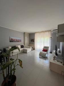 兰恰诺Casa del Verde - spazioso appartamento con terrazzo e giardino的客厅配有沙发和椅子