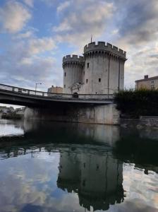 默兹河畔凡尔登Le gîte embarqué - Géré par Presta-Zen'Services - Barque électrique en supplément的一座城堡,在一座水体上的桥梁上