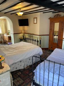 卡菲利Prince of Wales inn的一间卧室配有两张床和一台平面电视