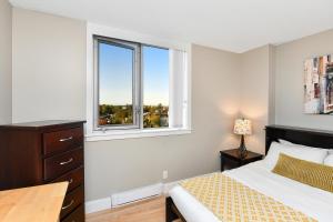 维多利亚Harbour Walk Executive Condo的一间卧室配有一张带书桌的床和两个窗户。