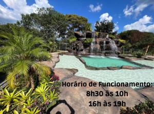 卡皮托利乌Pousada do Batata的庭院内带瀑布的游泳池