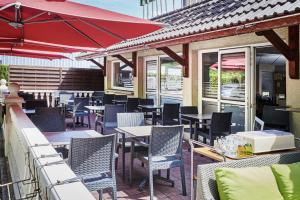 埃佩尔奈罗基斯巴格特尔酒店- 51530 迪斯的一个带桌椅和红色遮阳伞的庭院