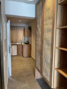 卡尔扎迈纳SunBeam的厨房设有走廊,通往带木制橱柜的厨房