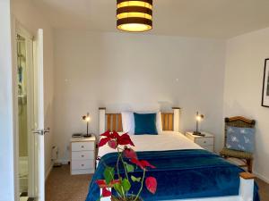 沃里克Jersey Villa Guest House的一间卧室配有一张带蓝色棉被的床