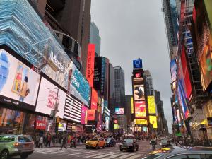 纽约Pestana CR7 Times Square的一条繁忙的城市街道,街道上有很多汽车和人,建筑