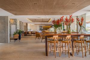 福塔莱萨普莱伊亚诺酒店的餐厅设有一张大型木桌和椅子