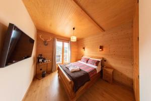 LloLa Masia Del Taulat Chambres d´Hôtes的小木屋内的卧室配有1张床和电视