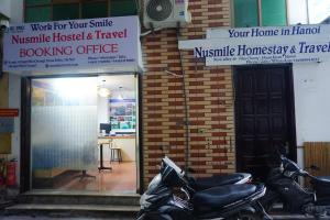 河内Nusmile's Homestay & Travel的停在大楼前的几辆摩托车