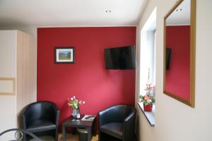 特赖斯-卡尔登科奈普旅馆的一间设有椅子和红色墙壁的等候室
