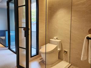 曼谷The SACHA Apart-Hotel Thonglor的一间带卫生间和玻璃门的浴室