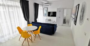 尼普顿OXYGEN NEPTUN BY BOUTIQUE C5的客厅配有蓝色的沙发、桌子和椅子