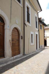 San Demetrio neʼ VestiniLa Rosa dei Pastori的街道上设有木门的建筑