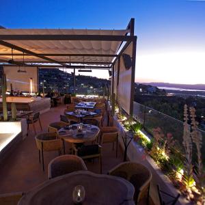 圣米格尔-德阿连德Hotel Amatte San Miguel de Allende的晚上在阳台上设有桌椅的餐厅