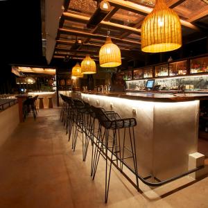 圣米格尔-德阿连德Hotel Amatte San Miguel de Allende的餐厅内带椅子和灯的酒吧