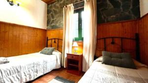 埃尔米瓜Casa Rural Ondina的一间卧室设有两张床和窗户。