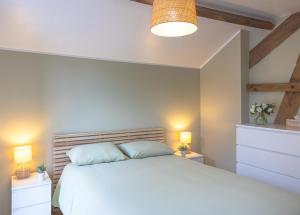 讷沙托Gîte Le Haut des Vannes的卧室配有白色的床和2个床头柜