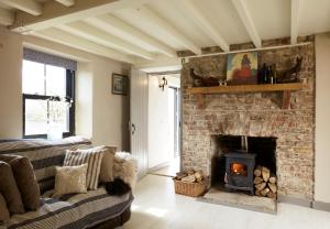 Coolkenna StreetKilquiggan Cottages的客厅设有砖砌壁炉和沙发。