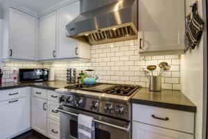 旧金山San Francisco Getaway Near Golden Gate Park的厨房配有白色橱柜和炉灶烤箱。