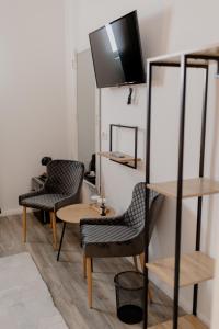 布泽乌No. 55的一间设有两把椅子、一张桌子和一台电视的房间
