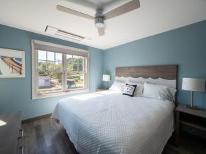 格洛斯特Long Beach Suites的一间卧室配有一张带蓝色墙壁的大床