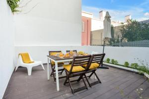 里斯本Modern 2 Bedroom Apartment in Estrela with Outside Terrace! Amazing for Families, Couples, Friends的庭院里的餐桌和椅子