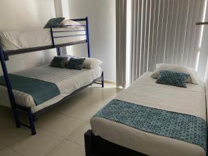 博卡德尔里奥Apartamentos Frente a La Playa Boca del Rio的一间卧室设有两张双层床和一扇窗户。