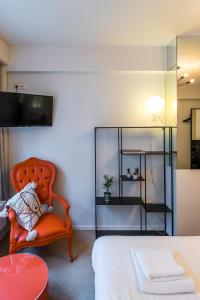 安特卫普Japie rooms - in the heart of Antwerp的一间卧室配有一张床和一张橙色椅子