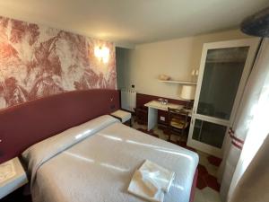 莱万托玛格丽塔别墅酒店的酒店客房配有一张床铺和一张桌子。