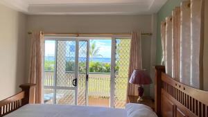 努库阿洛法Sky Lodge的一间卧室配有一张床,享有海景