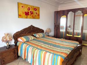 拉乌Grand appart avec vue sur mer的卧室配有一张床,墙上挂有绘画作品