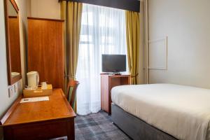 布里斯托阿诺斯庄园酒店的酒店客房配有一张床、一张书桌和一台电视。