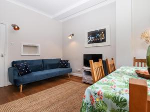 桑德维奇Carpenters的客厅配有蓝色的沙发和电视