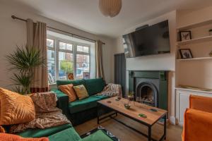 南安普敦Stylish Southampton City Centre House的客厅设有绿色沙发和壁炉