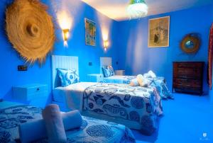 舍夫沙万CASA TROUSSI的蓝色卧室设有两张带蓝色墙壁的床