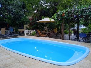 沙帕达-杜斯吉马朗伊斯Pousada do Didi Chapada dos Guimaraes.的院子里的大型蓝色游泳池