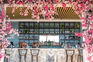 凯里尼亚Riverside Garden Resort的天花板上挂着粉红色花的酒吧