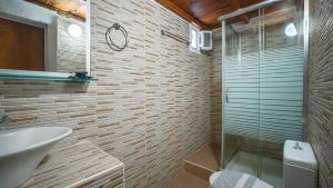 鲁特罗尼基别墅公寓的带淋浴、盥洗盆和卫生间的浴室