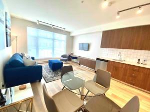 悉尼Perfect Brand New Condo In The Heart of Sidney的客厅配有蓝色的沙发和椅子