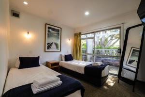 怀希比奇Tasman Holiday Parks - Waihi Beach的带窗户的客房内的两张床