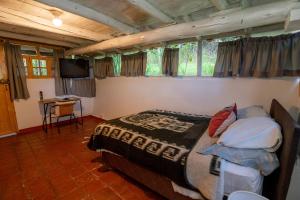 Los Baños del IncaCabaña Kinti Q'umir Umiña en Kinti Wasi的一间卧室配有一张床和一台电视